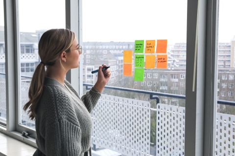 Women writing notes on notes pad at wind